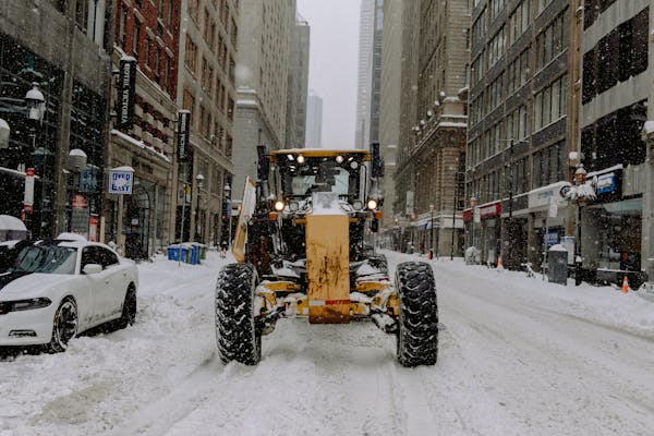 Commercial parking lot being plowed by loader during Calgary winter